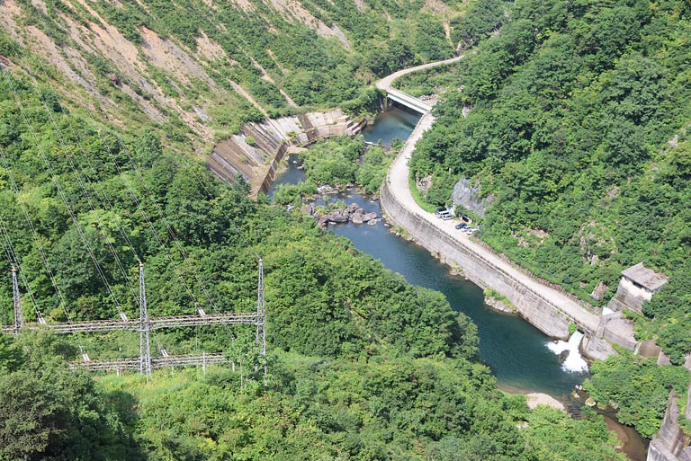 ダムの下を流れる只見川。川の環境を守るため、河川維持流量が常に放流されています。送電線も見えました