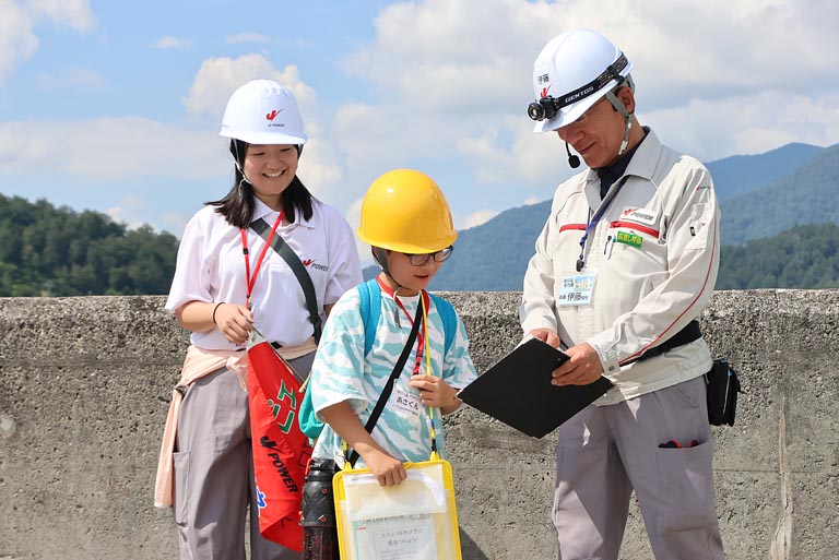 天端を歩きながら発電所について質問!「この下に発電所がある!」と地下発電所に興味津々